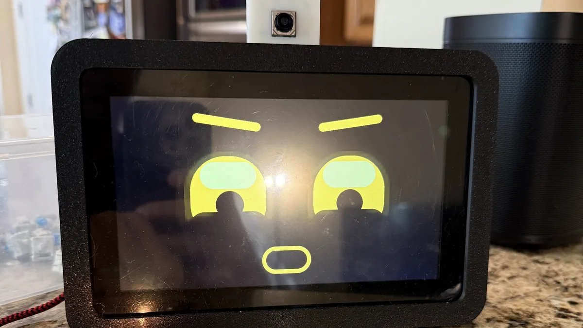 Bam's touchscreen face in its 3D-printed frame, with raised eyebrows and a surprised little mouth